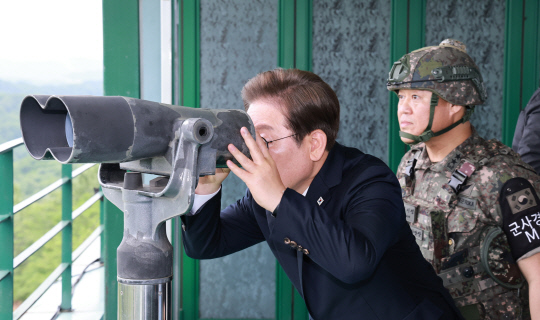 이재명 대통령이 13일 경기도 연천군 육군 25사단 비룡전망대에서 망원경으로 북측 지역을 보고 있다. 연합뉴스